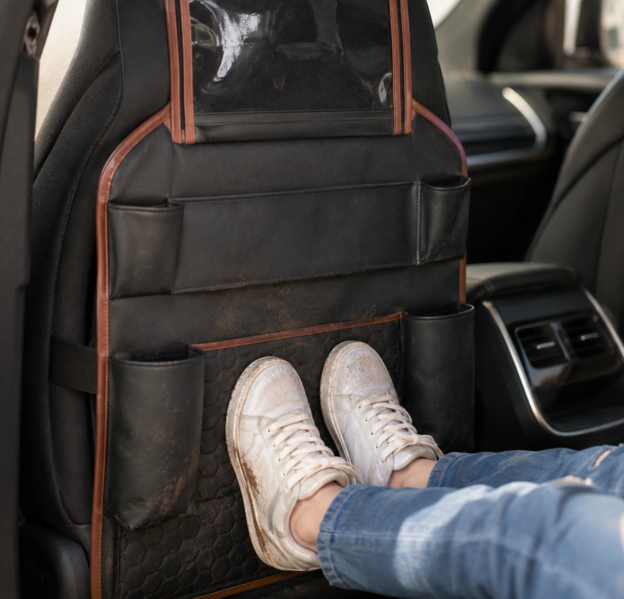 Muddy sneakers resting on the organizer instead of the upholstery